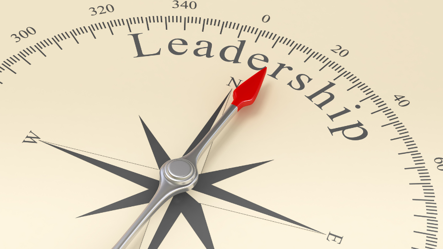 Gros plan d'une boussole dont l'aiguille rouge indique la direction du mot Leadership.
