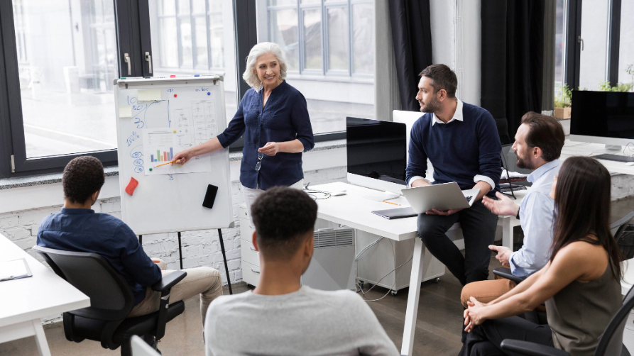 Formation professionnelle en marketing digital à Agadir, experte certifiée Mindfull présente une stratégie sur un tableau blanc devant une équipe attentive