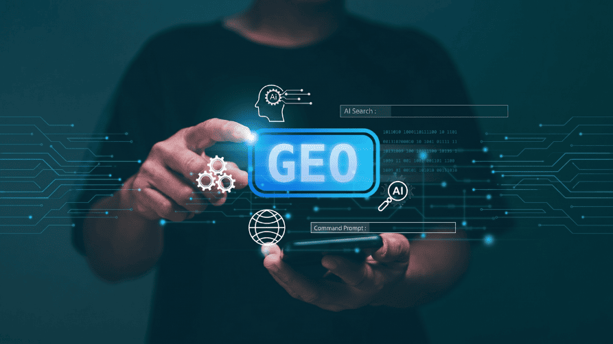 A person holding a smartphone with a glowing, augmented reality interface hovering above it. The central focus of the interface is a bright blue button displaying the word "GEO". The surrounding digital display includes tech-themed icons such as a wireframe globe, interlocking gears, a silhouette of a head containing an AI brain, and a magnifying glass with "AI" inside. Floating text boxes read "AI Search :" and "Command Prompt :" against a dark teal background.