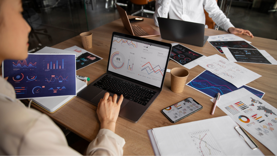 Une équipe d'entreprise analyse des données analytiques de performance digitale complexes lors d'une réunion de planification stratégique.